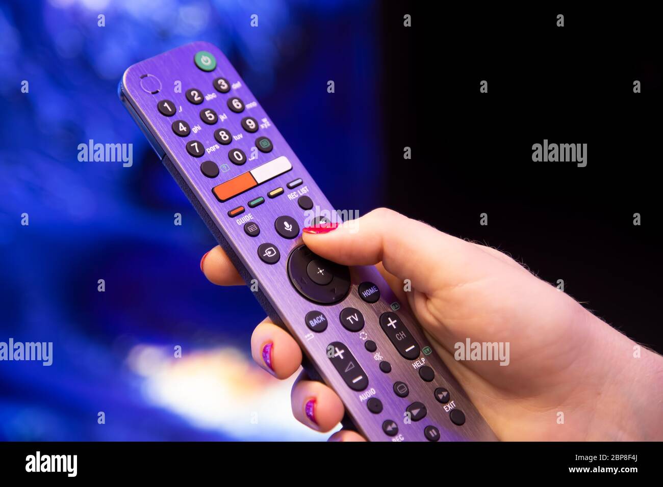 female hand holds a smart TV remote control with microphone and voice  control. background in blur. soft focus Stock Photo - Alamy