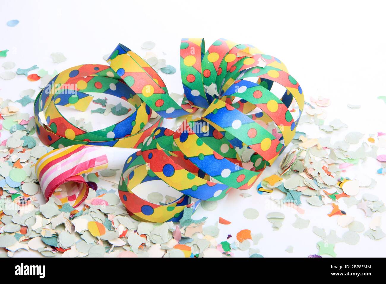 Luftschlangen und Konfetti als Partydekoration für Geburtstag mit weißem Hintergrund Stock Photo