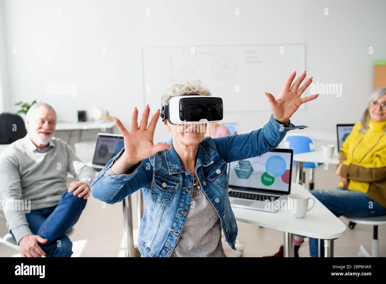 Group of seniors with VR goggles on computer and technology education class. Stock Photo