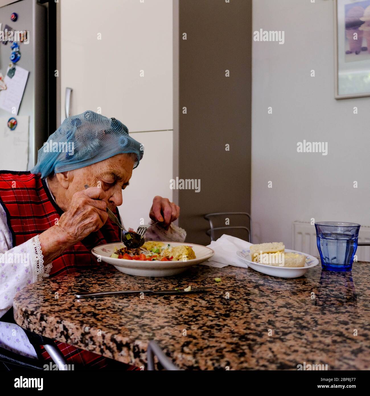 Elderly Woman Eating Alone, Self Isolating During The UK Coronavirus Lockdown, Eating A Meal Stock Photo