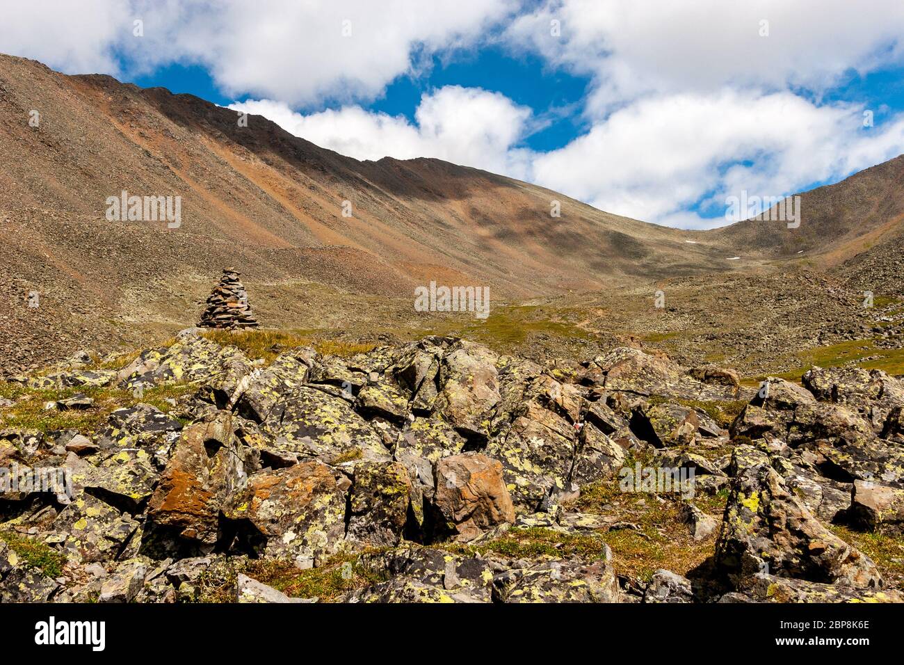 Mountain landscape with split rocks and a mountain range in the clouds ...