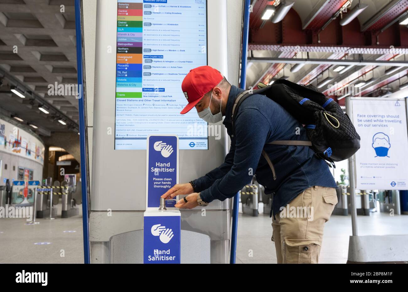 Commuters using hand sanitiser points at Waterloo Underground station during the coronavirus pandemic. May 2020 Stock Photo