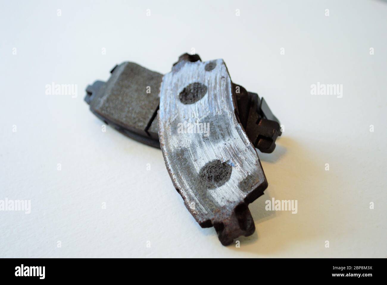 Worn out ruined disc brake pad compared to one that is new Stock Photo