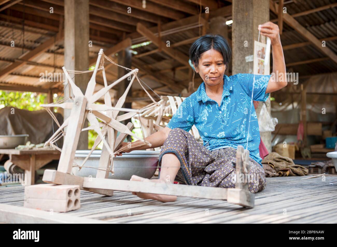 Woman spinning silk on a traditional spinning wheel. Silk Island, Phnom Penh, Cambodia, Southeast Asia Stock Photo