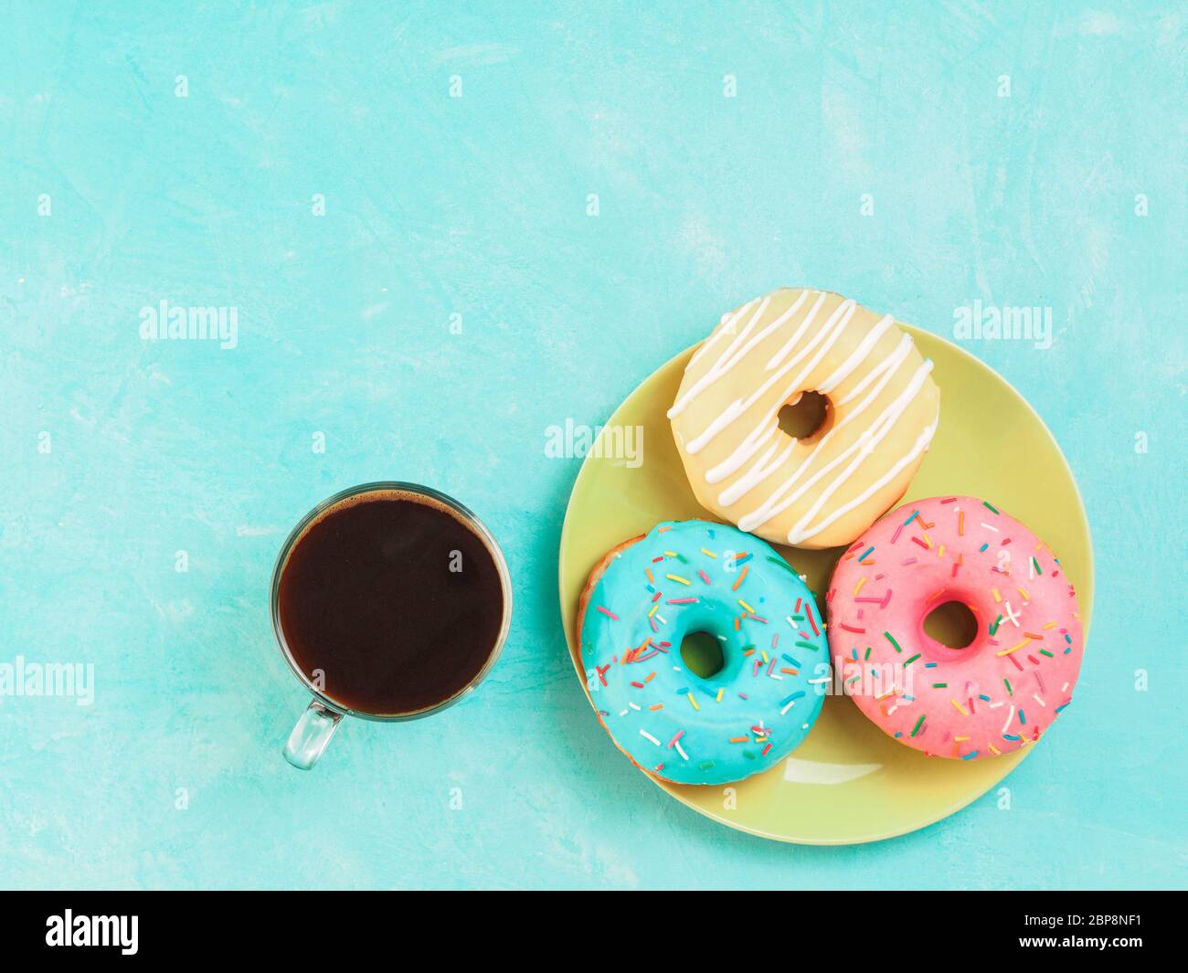 Top view of assorted donuts and coffee on blue concrete background with ...