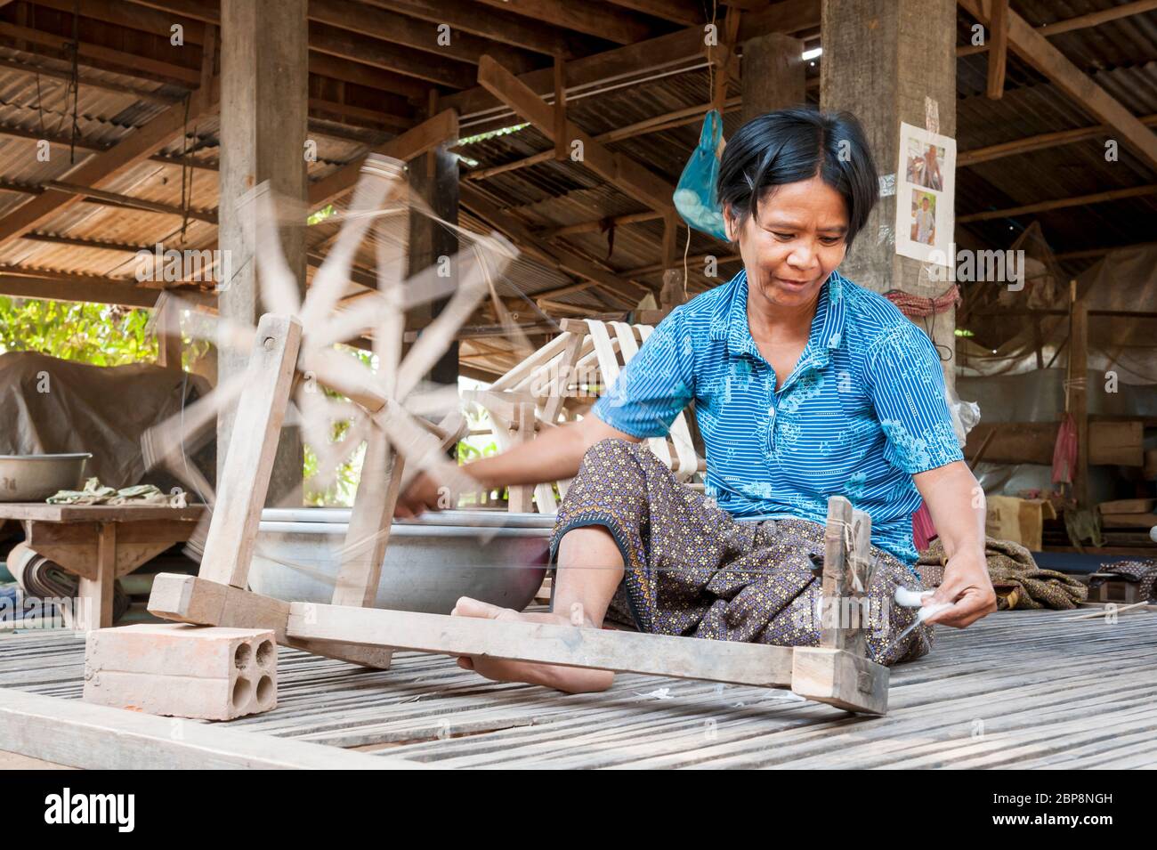 Woman spinning silk on a traditional spinning wheel. Silk Island, Phnom