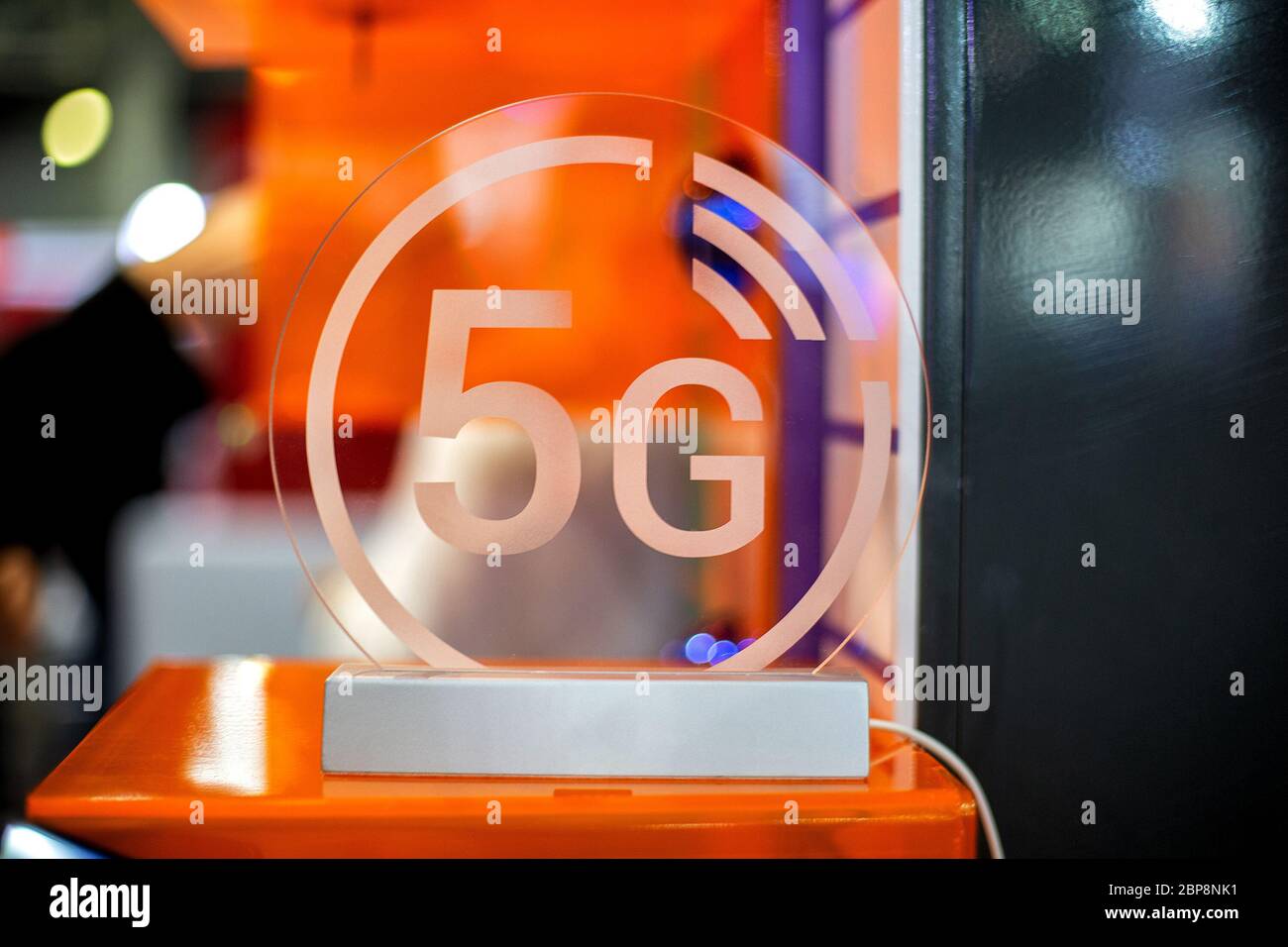 5g white icon on transparent plastics. Orange background in blur. close up, front view Stock Photo