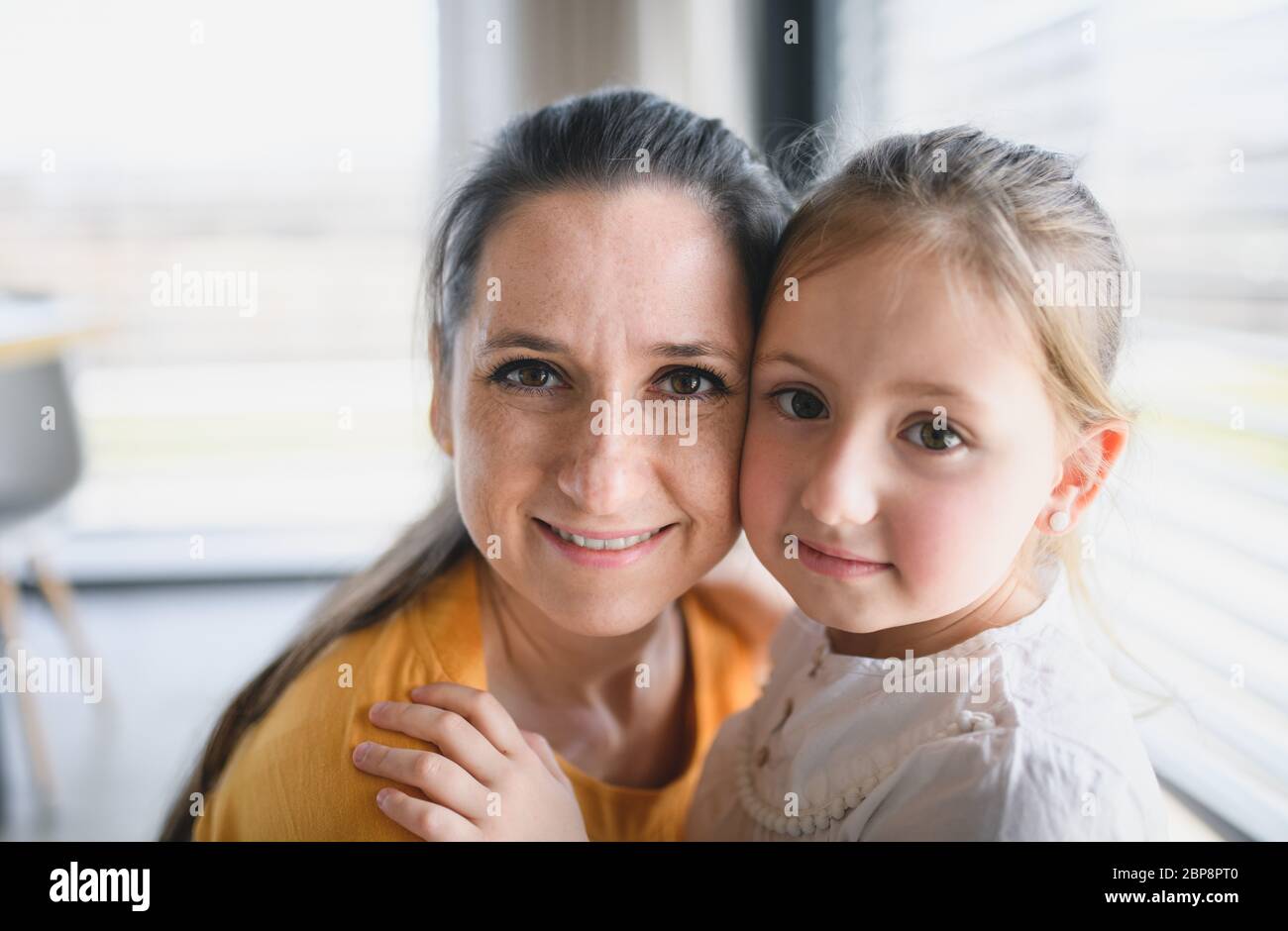 Mother and child indoors at home, looking at camera Stock Photo - Alamy