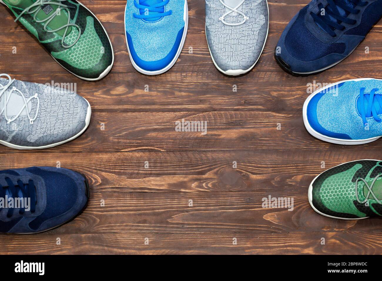 Top view shop display of unbranded modern new stylish sneakers running  shoes for men on wooden background texture with copy space Stock Photo -  Alamy