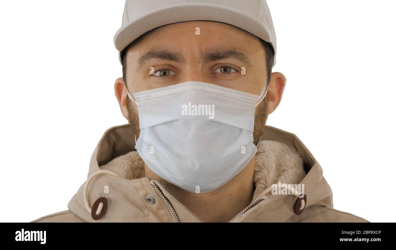 Sick young man handsome wearing medical mask on white background. Stock Photo