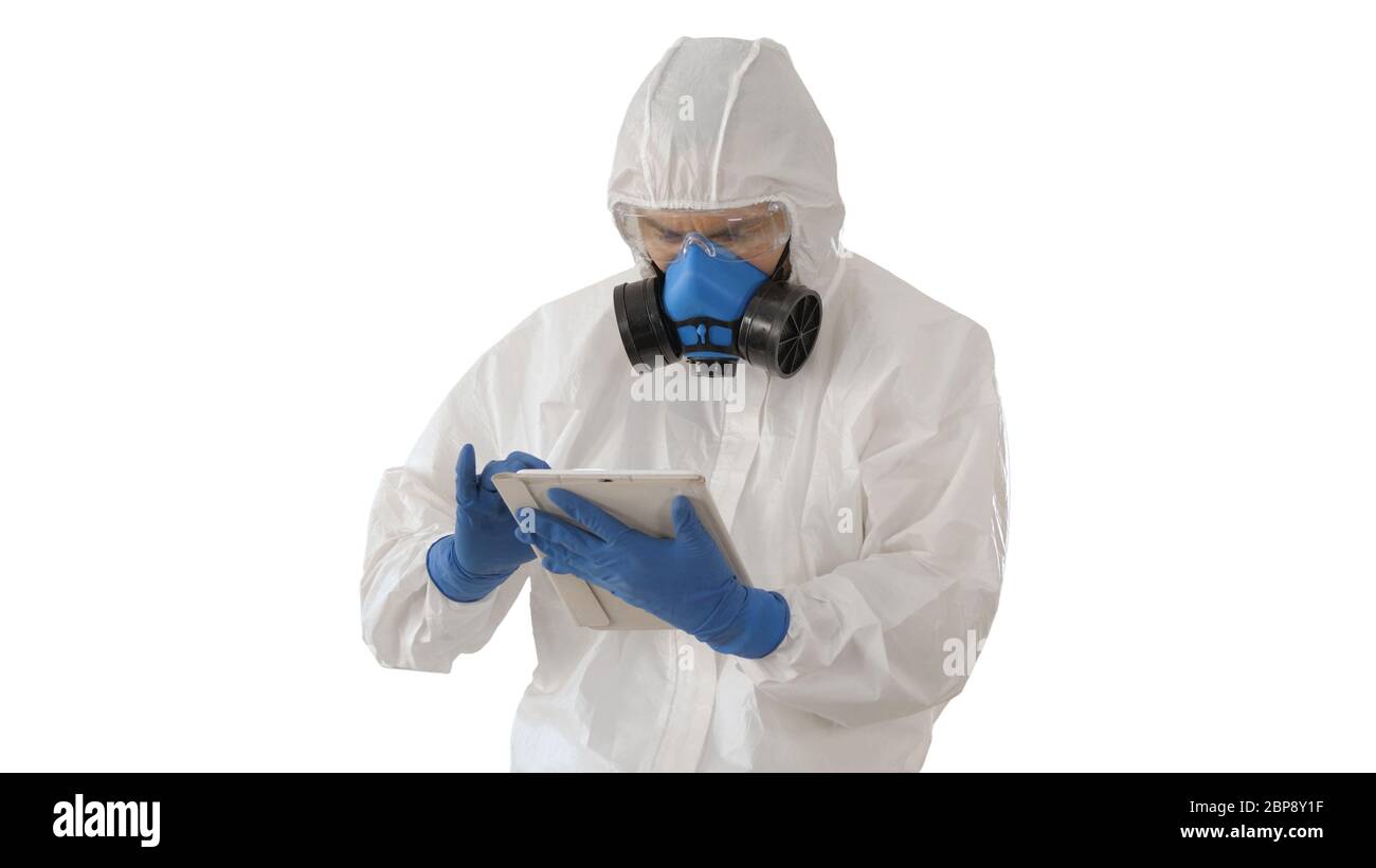 Male doctor in protective suit using digital tablet on white background. Stock Photo