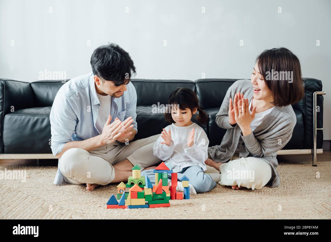 Mom and Dad and daughter at home building blocks Stock Photo - Alamy