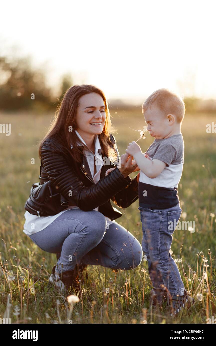Mother and her little son playing with dandelions Stock Photo - Alamy