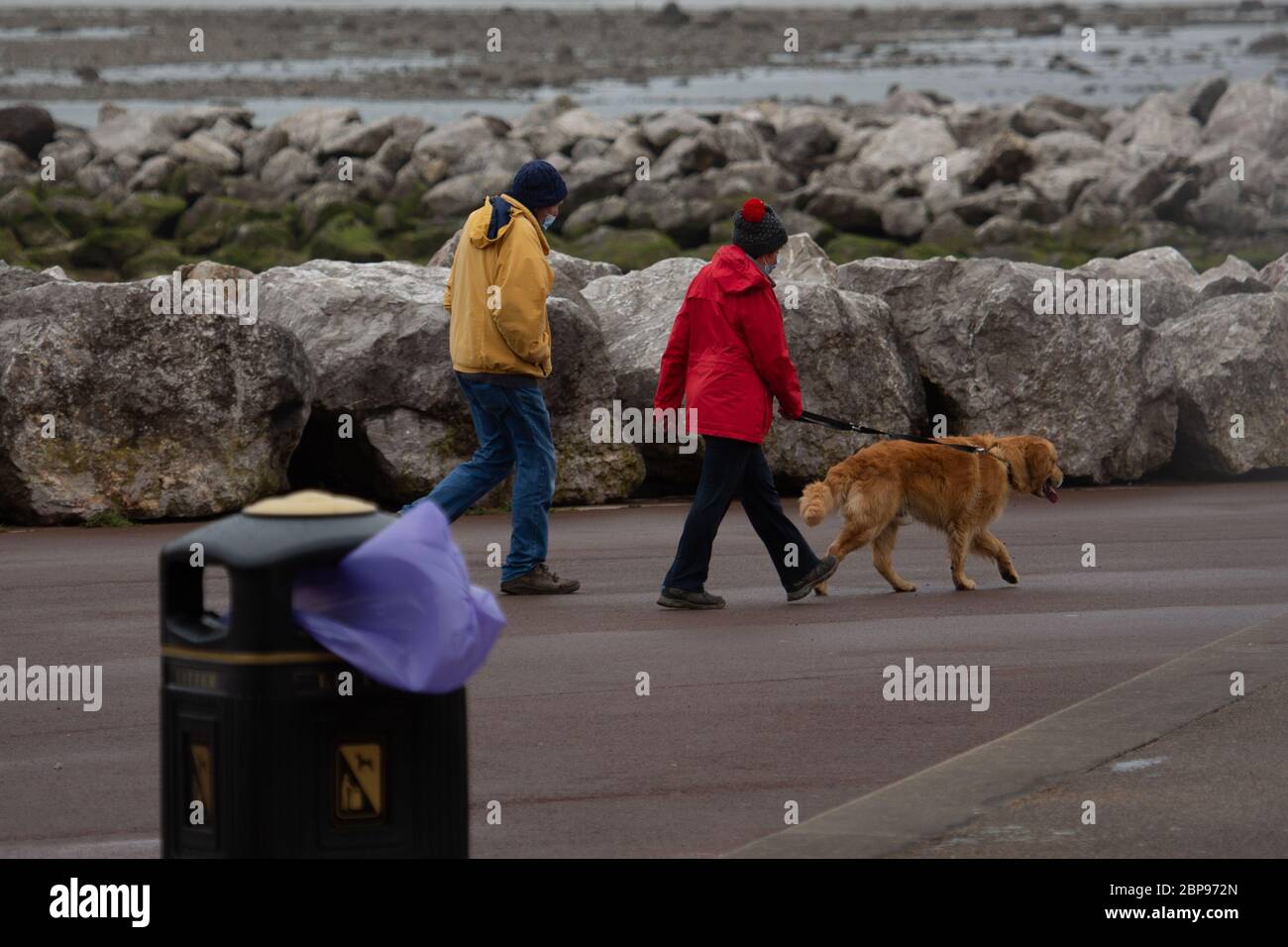 Morecambe, Lancashire, United Kingdom. 18th May, 2020. The weather turns with dog walks battling high winds and rain blowing down the promenade Credit: PN News/Alamy Live News Stock Photo