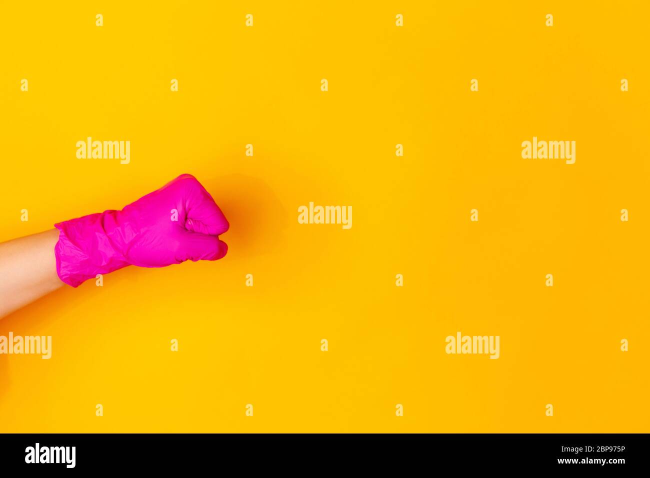 Hand in pink protective rubber glove showing fist bump isolated on ...