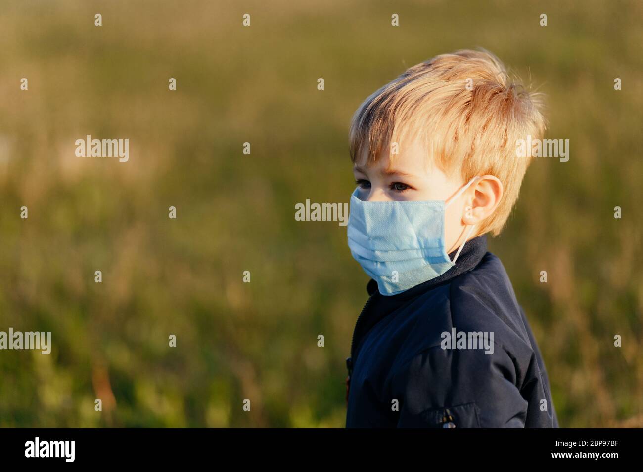 Little blonde boy wearing the medicine mask outside Stock Photo - Alamy