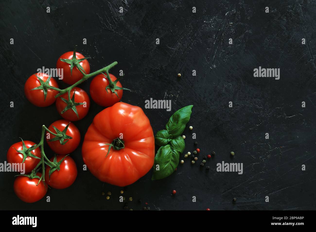 Fresh tomatoes on a black background with spices. Top view Stock Photo ...