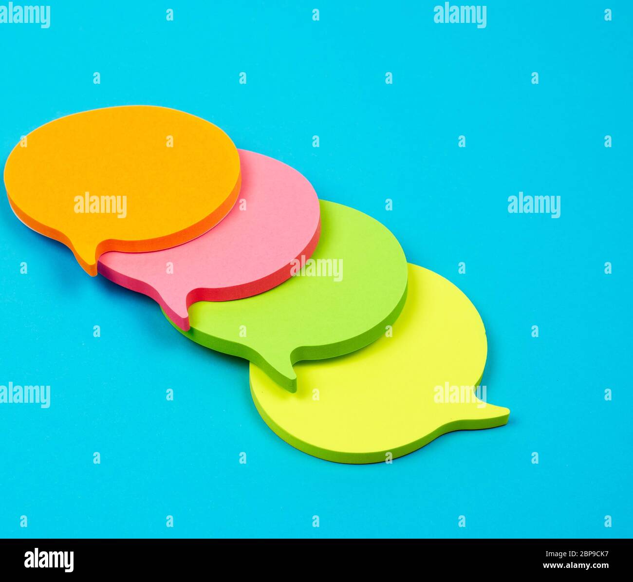 stack of multicolored empty paper stickers in the form of clouds on a blue background Stock Photo
