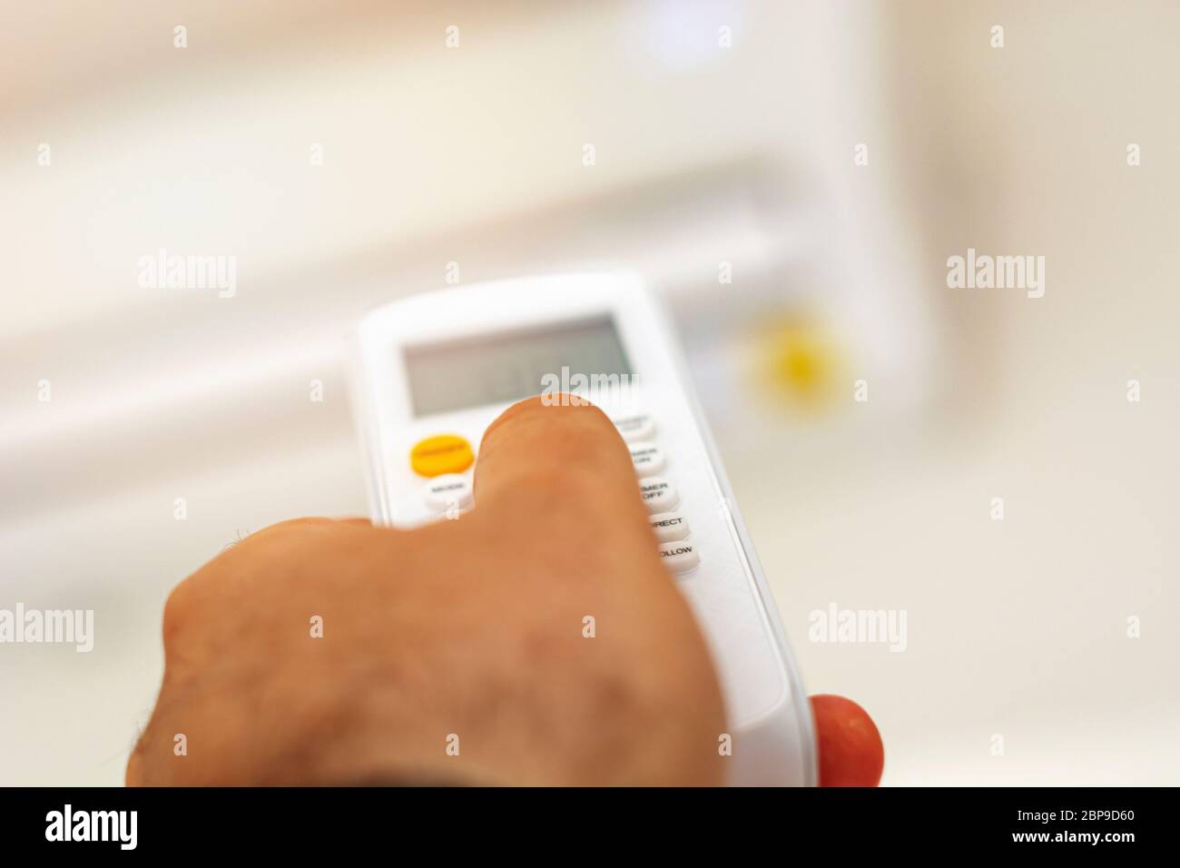 closeup view of a hand adjusting the air conditioning temperature
