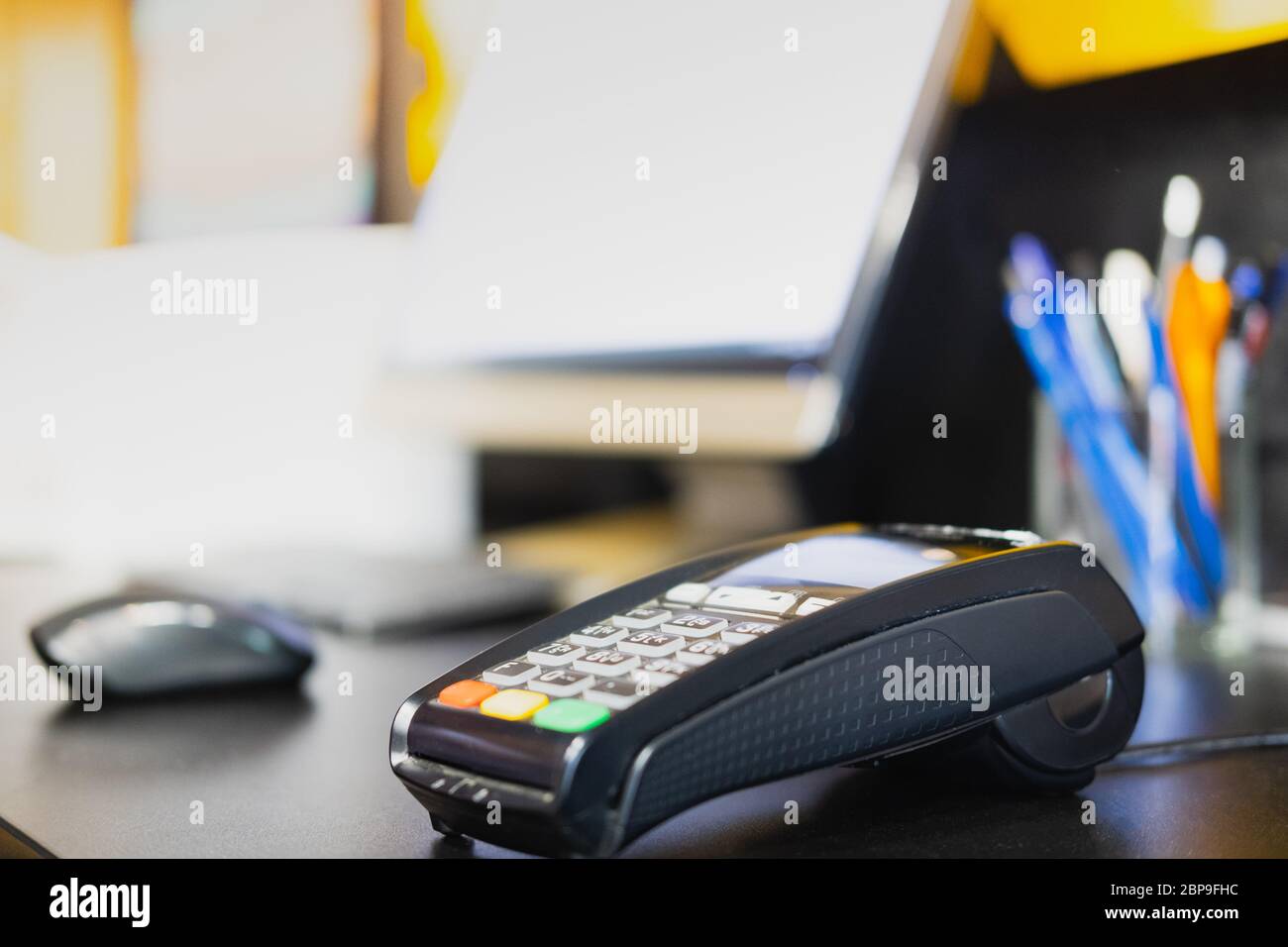 Payment terminal on a table, close-up view. POS terminal at cashier desk of a retail store, local business concept Stock Photo