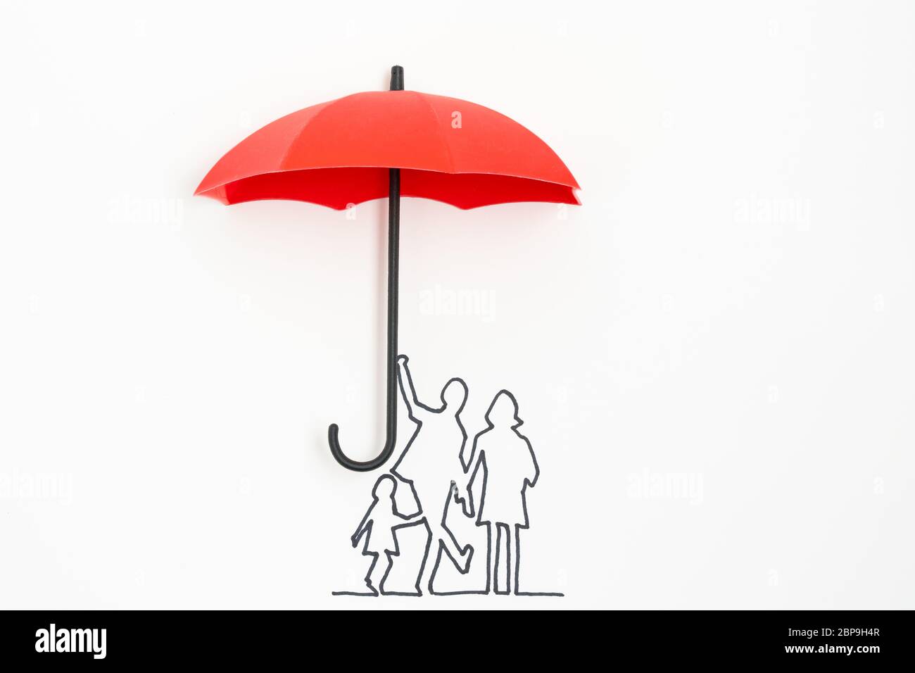 Family protection insurance concept using red umbrella Stock Photo
