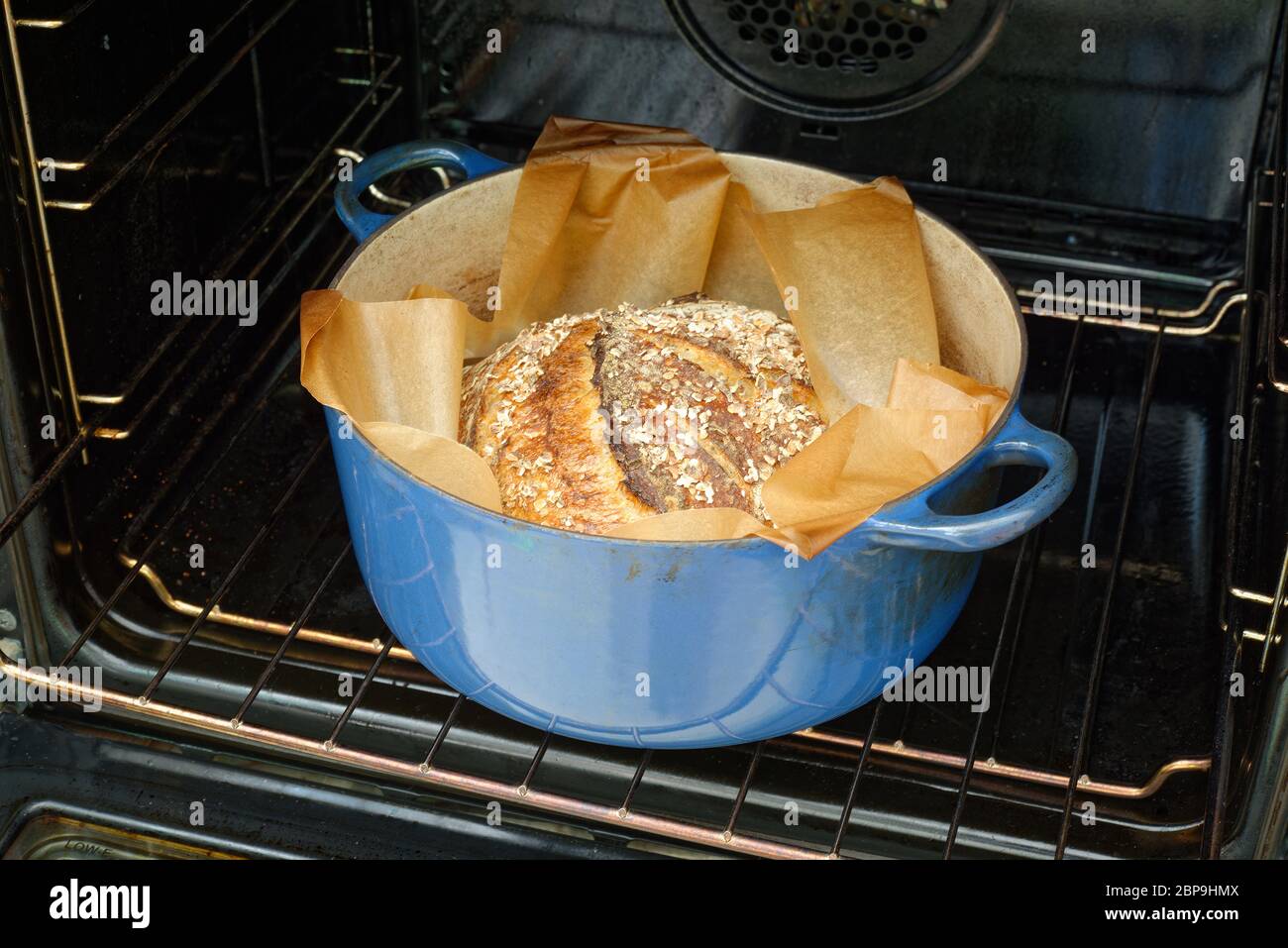 Home made bread. Sourdough bread loaf as the oven is opened. Stock Photo