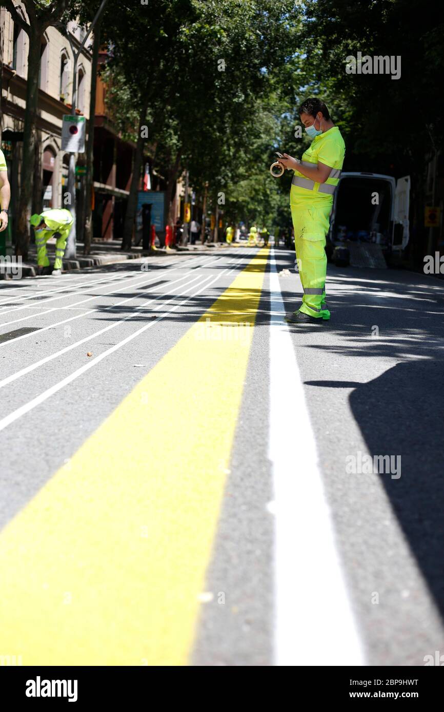 Barcelona, Spain. 18th May, 2020. BARCELONA, SPAIN - MAY 18: Urban signalling workers are seen labelling the new pedestrian lanes to comply with the mandatory distances due to the Covid-19 contagion. The Barcelona City Council implements 21 km of a new bicycle lane and 12 km of new sidewalks for pedestrians to ensure the safety distance due to the contagion of the Covid-19 on May 18, 2020 in Barcelona, Spain. Photo by Elkin Cabarcas/Cordon PressPhoto by Elkin Cabarcas/Cordon Press Credit: CORDON PRESS/Alamy Live News Stock Photo