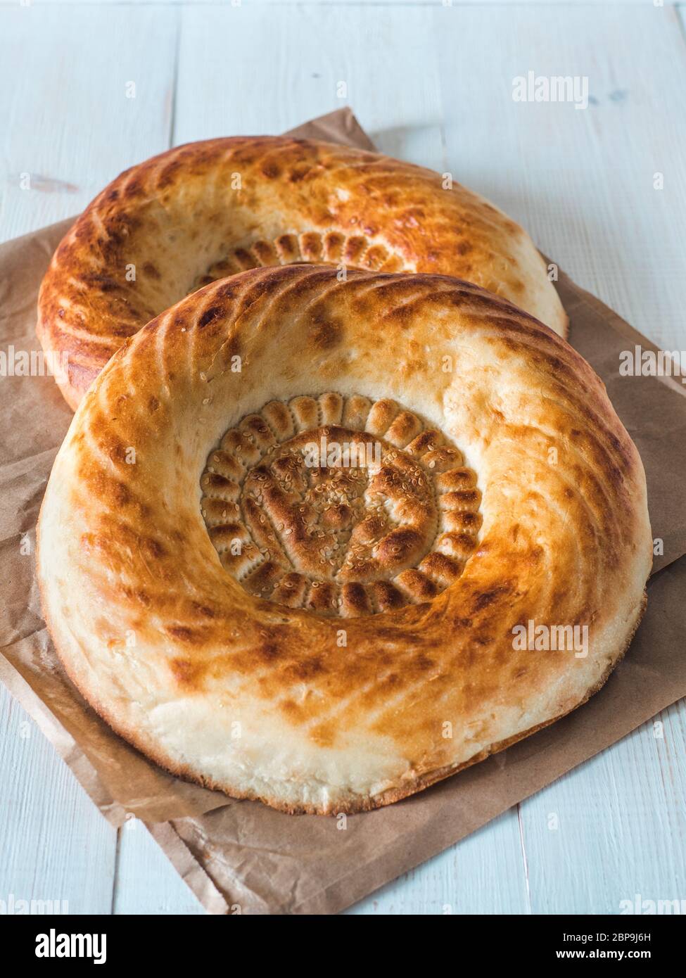 Tasty fresh tandoor bread on white wooden table. Two tandoor flat bread  cake. National asian meal, food, bread. Vertical Stock Photo - Alamy