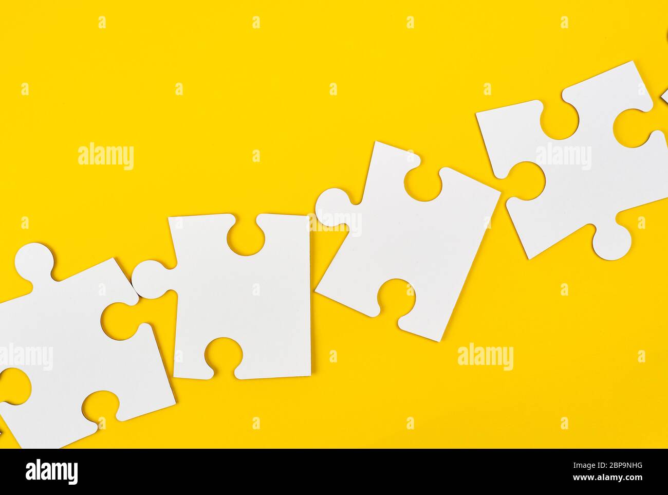 blank white big puzzles on yellow background, flat lay Stock Photo
