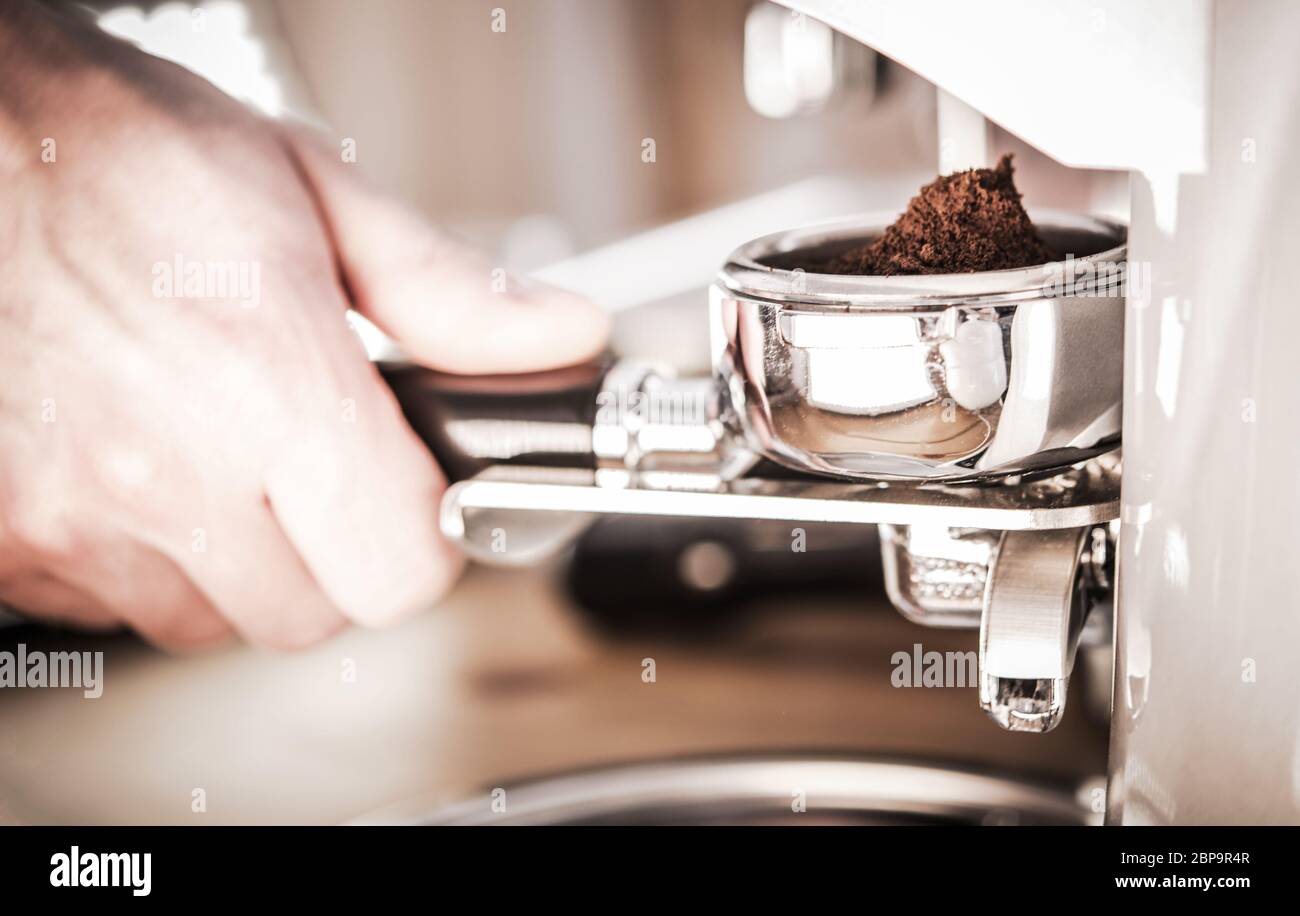 Close Up Of Male Hand Near Coffee Machine Grinding Beans And Pouring