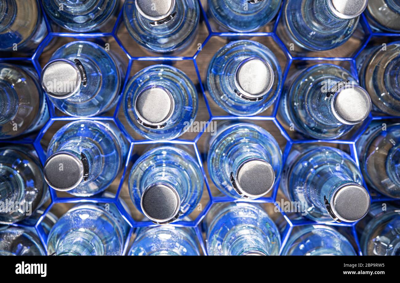 Multiple Glass Water Bottles With Pop Up Tops Organized In Blue Wire Holders Stock Photo Alamy