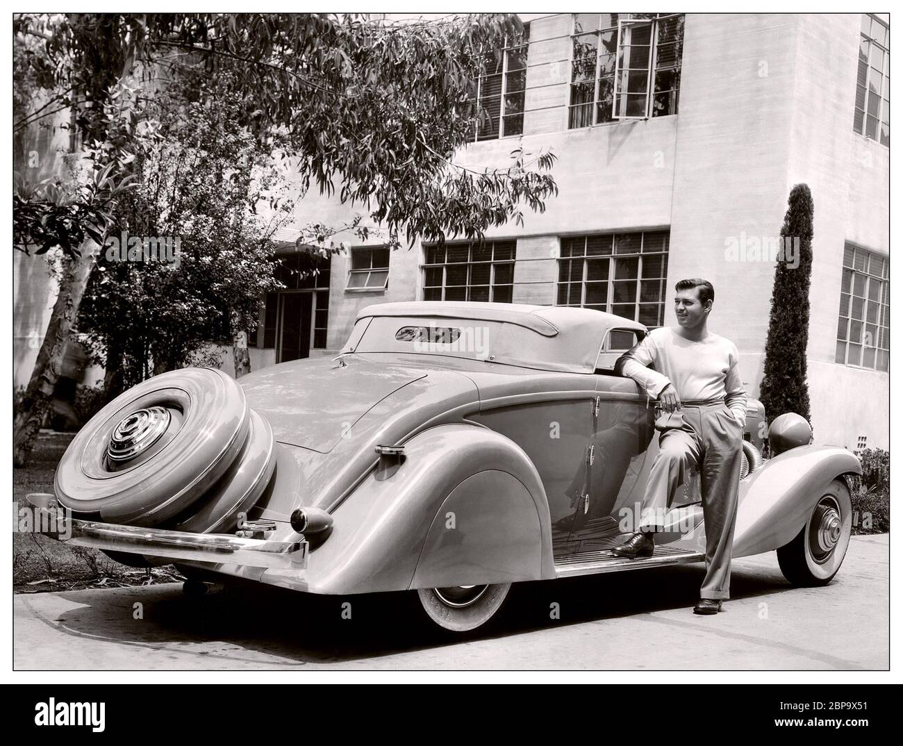 Clark Gable 1930’s Archive Image with Duesenberg JN 560/2585 Convertible Coupe SWB by Bohman & Schwartz, & Clark Gable This car was purchased in 1935 by Clark Gable and was originally bodied by Rollston as a convertible coupe. It was restyled by Bohman & Schwartz of Pasadena, CA, to sketches created to reflect ideas and shapes suggested by Gable himself. It was used by Gable during his courtship of Carole Lombard, and was frequently used during their marriage, then abandoned by Gable after her untimely death in 1942. Stock Photo