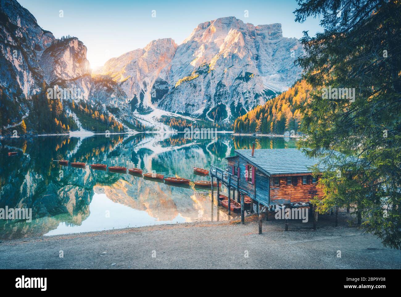 Boats and wooden house on the water on coast of Braies lake Stock Photo