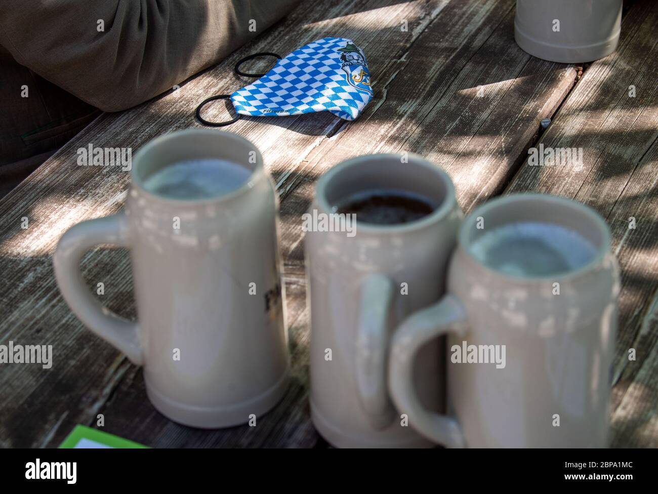 Munich, Germany. 18th May, 2020. A mouthguard is on the table next to beer mugs. In compliance with strict hygiene and distance rules, outdoor restaurants in Bavaria are allowed to open again until 8 p.m. after a corona break. Credit: Lino Mirgeler/dpa/Alamy Live News Stock Photo