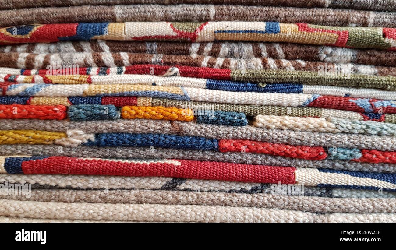 Stack of folded traditional Turkish rugs. Layers of colorful weaved carpets.  Woven yarn textured backdrop. Edges of ethnic vintage carpets. Pile of ha  Stock Photo - Alamy