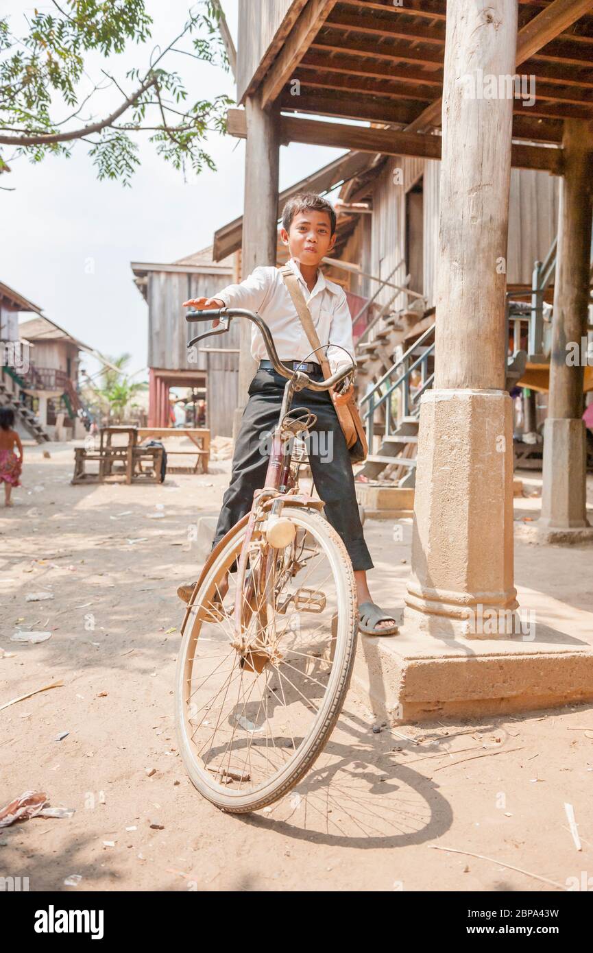 Young Muslim boy on a bike in a rural Cham village. Central Cambodia, Southeast Asia Stock Photo