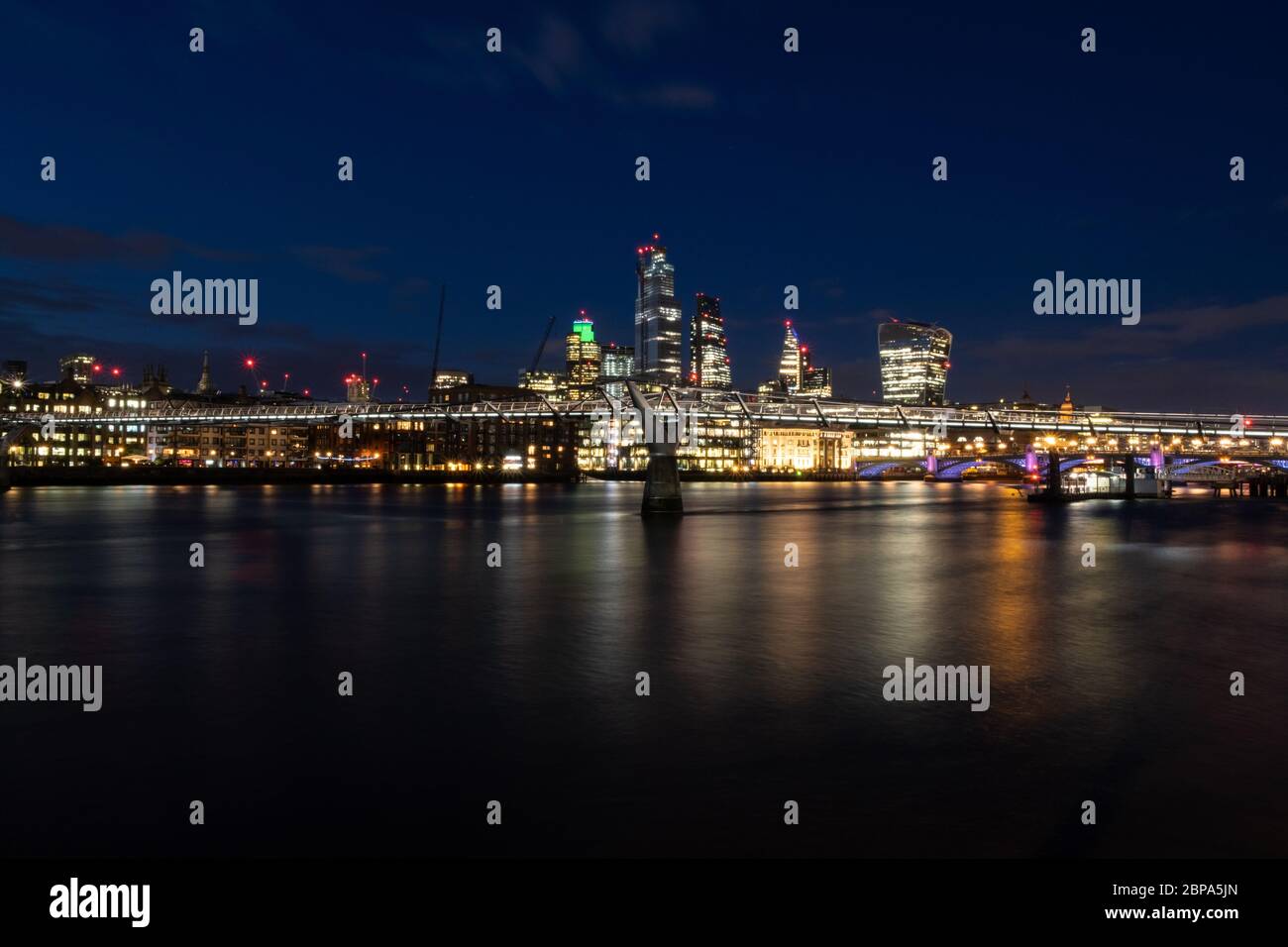 City of London, England, at night, with the Millennium Bridge, from the south bank of the River Thames Stock Photo