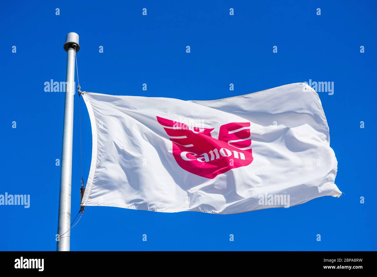 Canon flag proudly flying waving in the wind under blue skies at Canon  Solutions America headquarters campus in Silicon Valley - San Jose,  California Stock Photo - Alamy