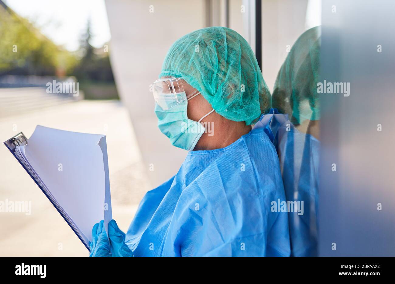 Nursing staff as a containment scout in front of clinic studies list for contact tracking in coronavirus pandemic Stock Photo