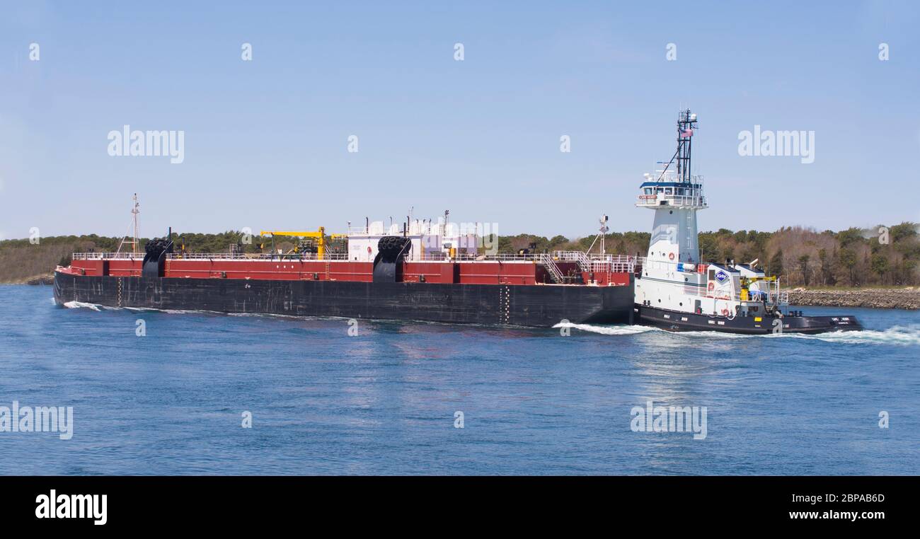 A barge and Tug passing through the Cape Cod Canal in Massachusetts, USA Stock Photo
