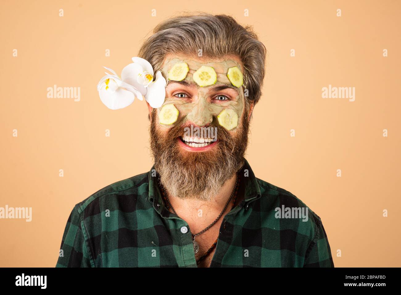 Funny man applied facial masks and cucumbers on face. Funny surprised