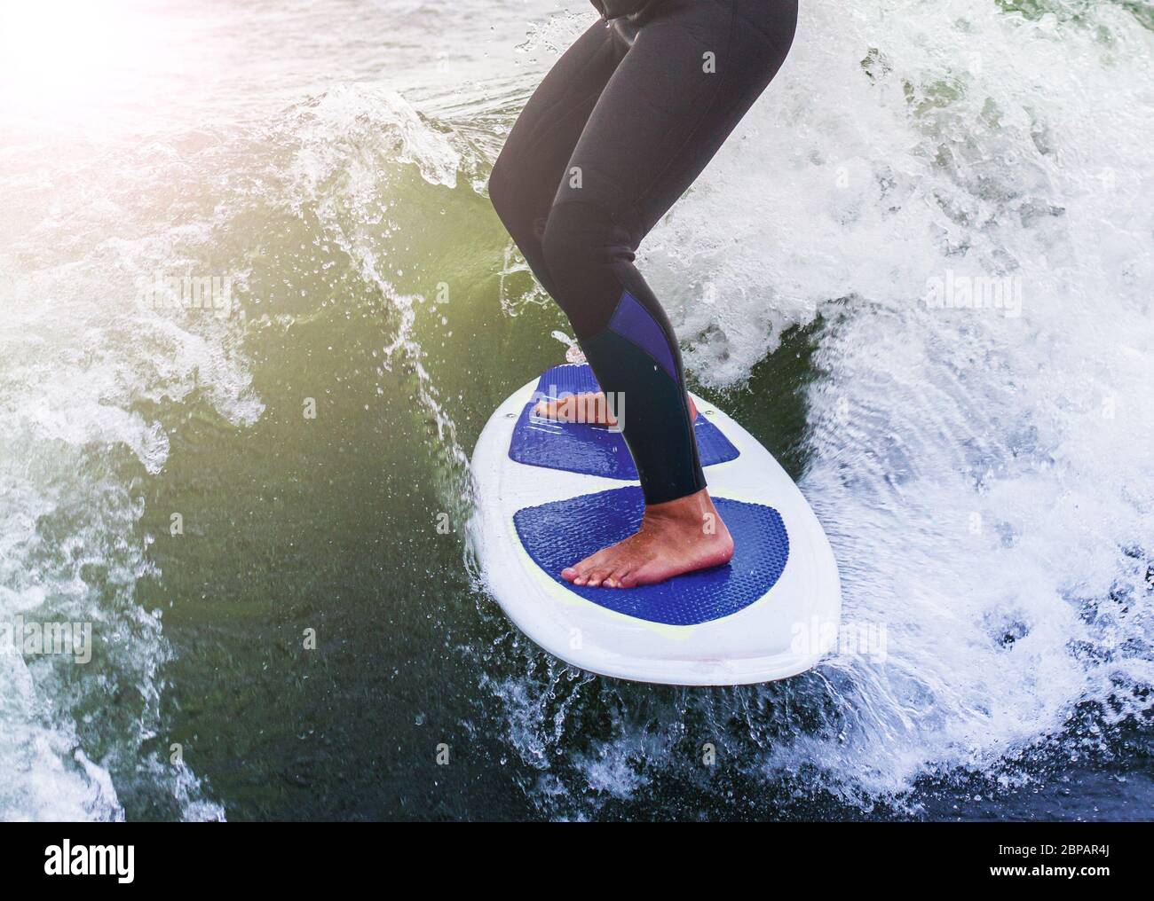Male water sports enthusiast stands safely on the wakeboard liability safety ease challenge water skiing risk fun surfing enjoyment of life hobby Stock Photo