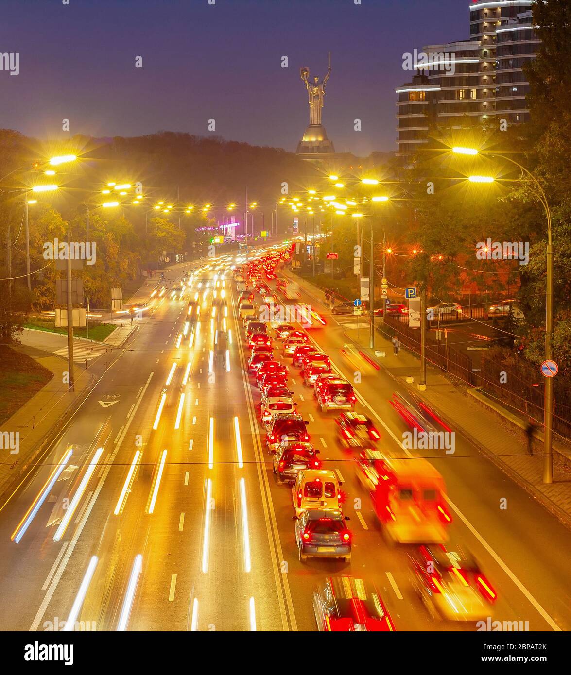 Evening traffic, illuminated city prospect, Motherland monument in background, Kiev, Ukraine Stock Photo
