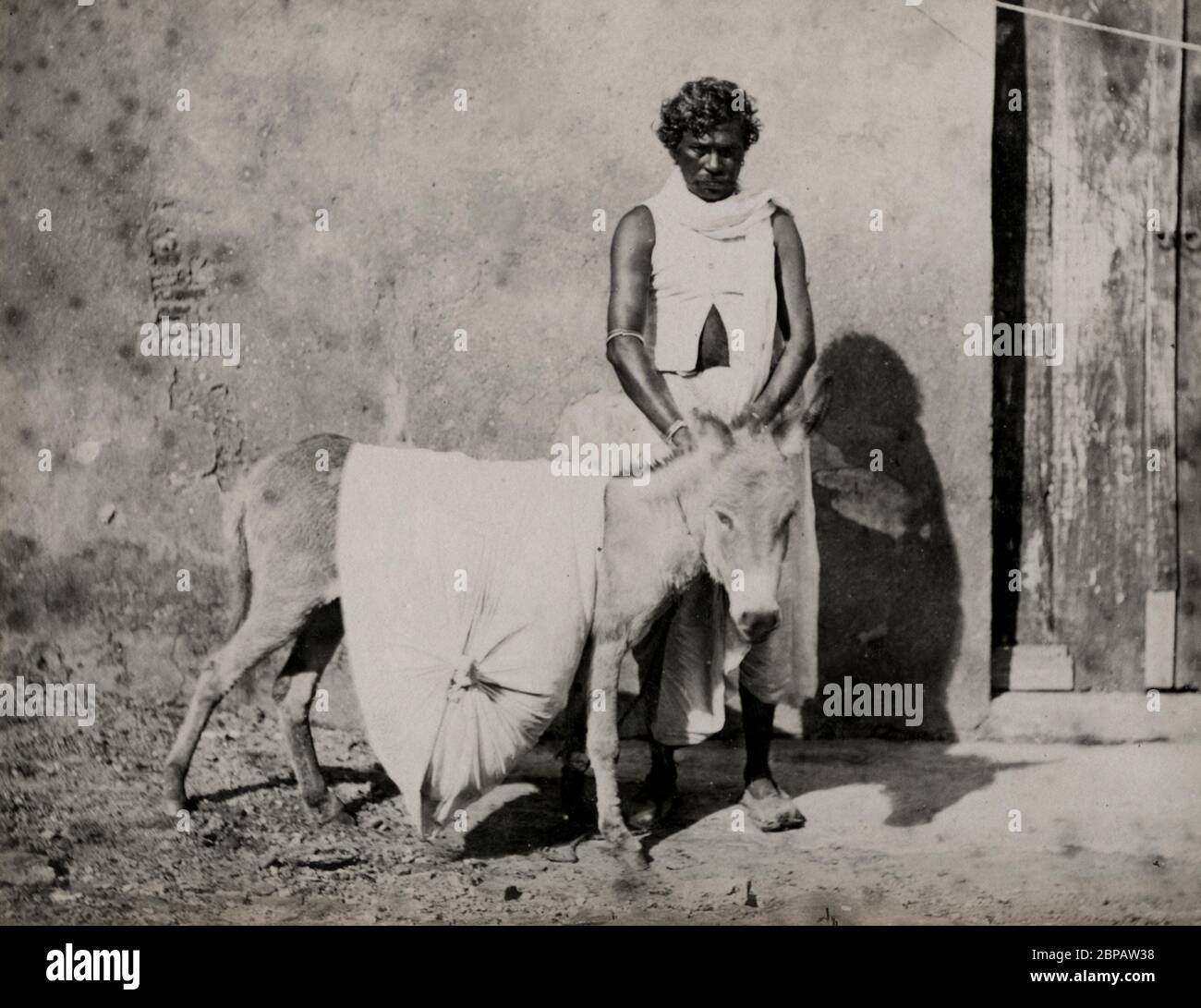 Indian man and donkey carrying a load Stock Photo