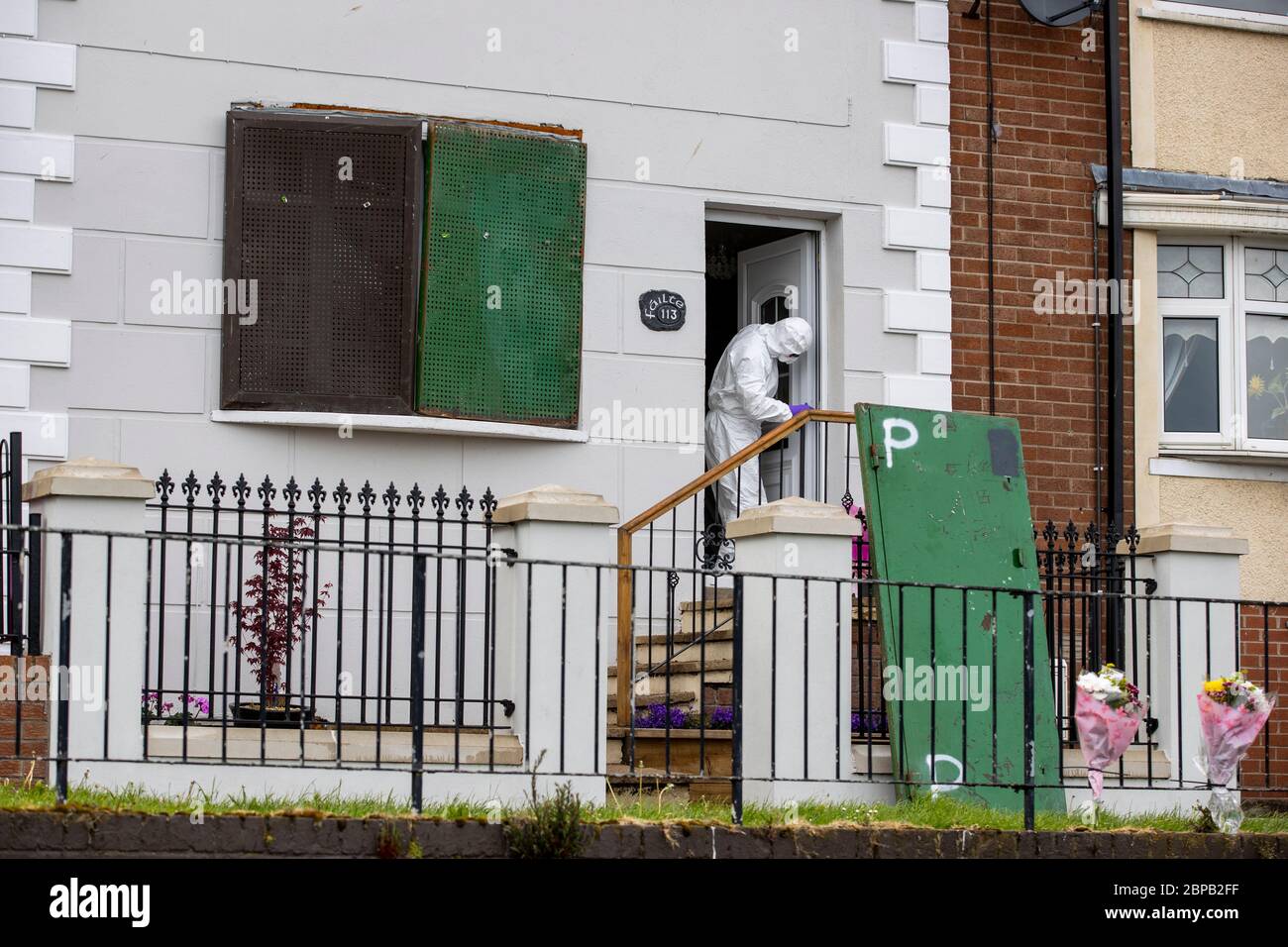 A forensic officer works at a property in Lenadoon Avenue in west Belfast, following the murder of 57 year old Keiran Wylie who was murdered at his home on Sunday night. Stock Photo