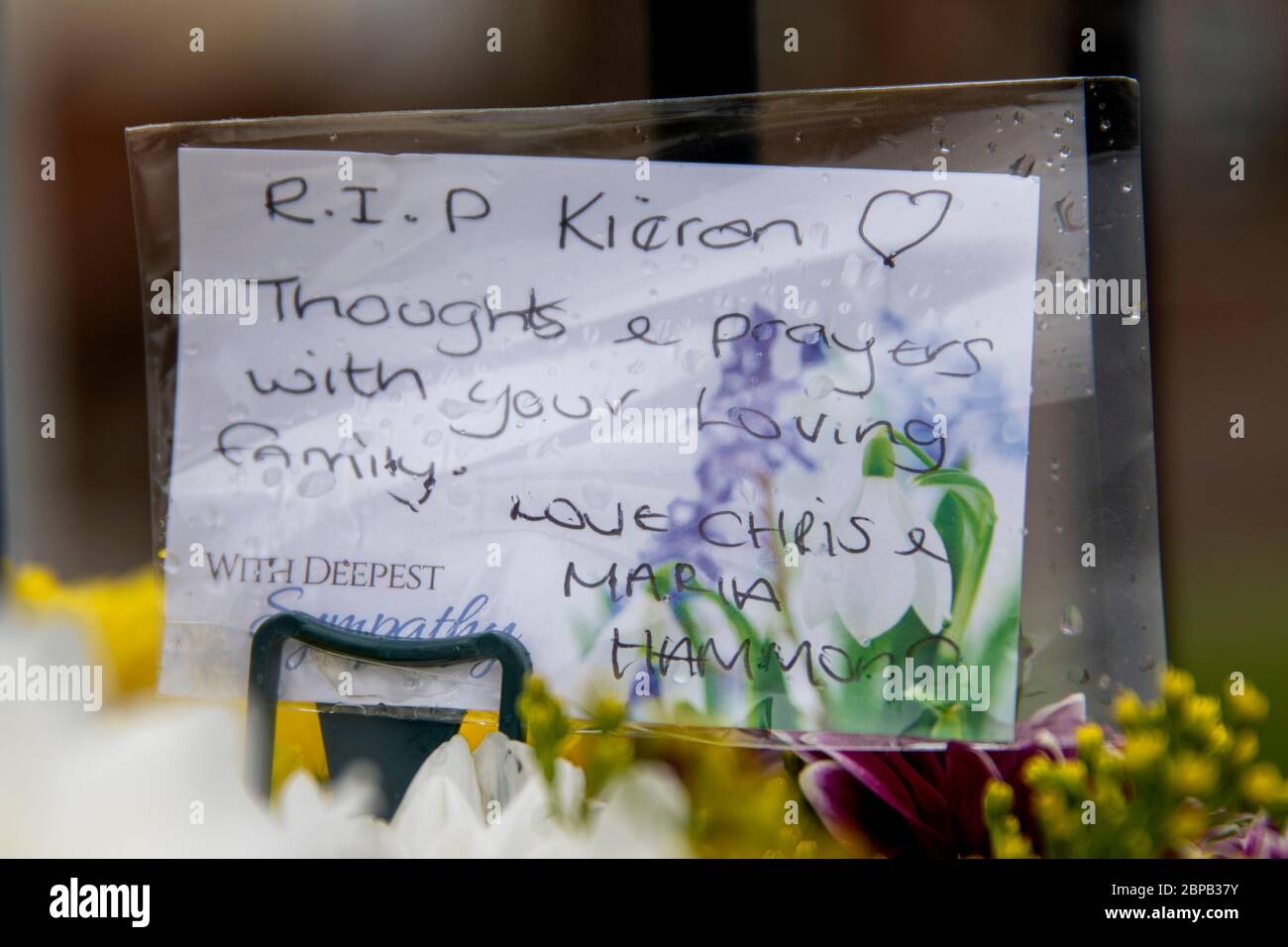 A note on flowers left near a property in Lenadoon Avenue in west Belfast, following the murder of 57 year old Keiran Wylie who was murdered at his home on Sunday night. Stock Photo