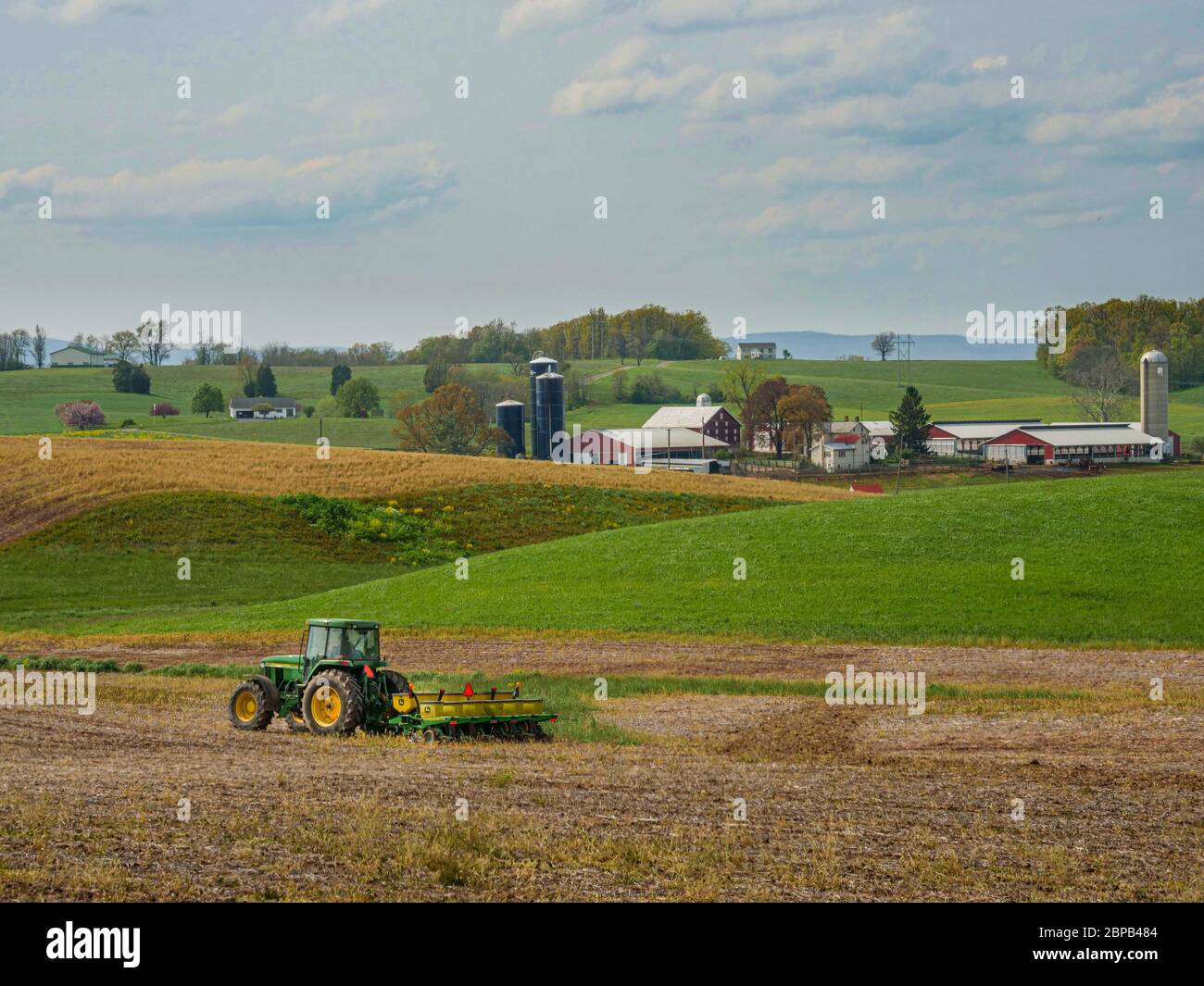 A farmer uses a tractor to prepare a no-till field for corn planting April 29, 2020 in Keymar, Maryland. Stock Photo