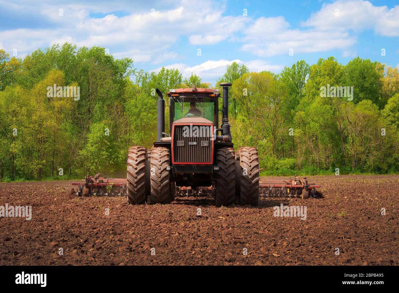 A farmer uses a tractor to till a field for corn planting May 12, 2020