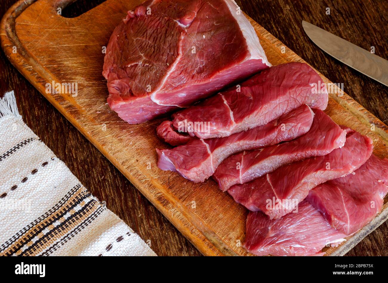 Portioned slices of raw meat on a cutting board. Fresh pieces of chopped  beef tenderloin close-up. Five juicy slices of beef. Ingredients for  preparin Stock Photo - Alamy