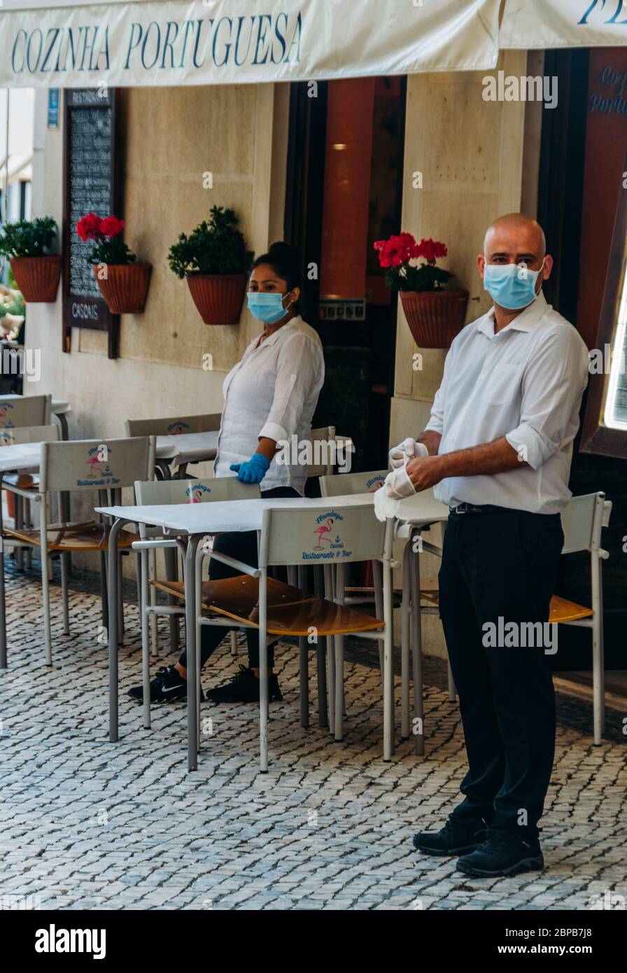 Waiters wearing face masks outside a restaurant in Cascais, Portugal